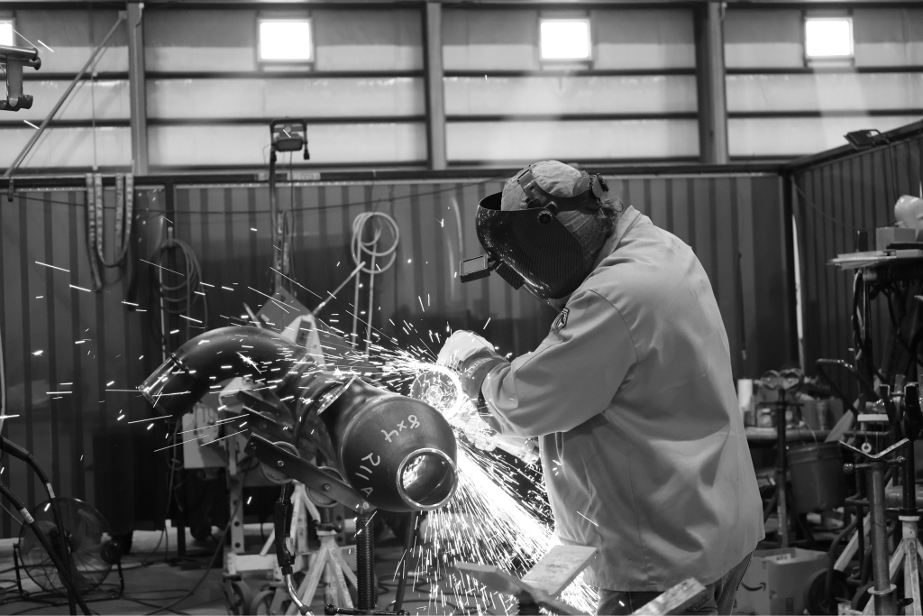 UPI team member cutting pipe in the fabrication shop
